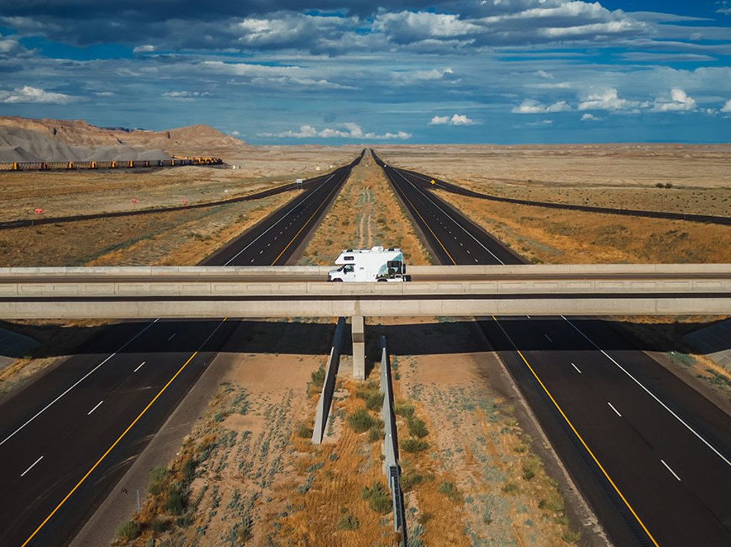 RV parked on overpass above interstate highway